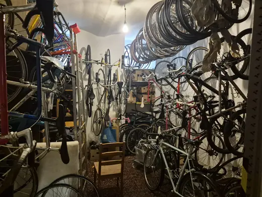 Dicht an dicht gelagerte Fahrräder und Laufräder im Kellerraum.